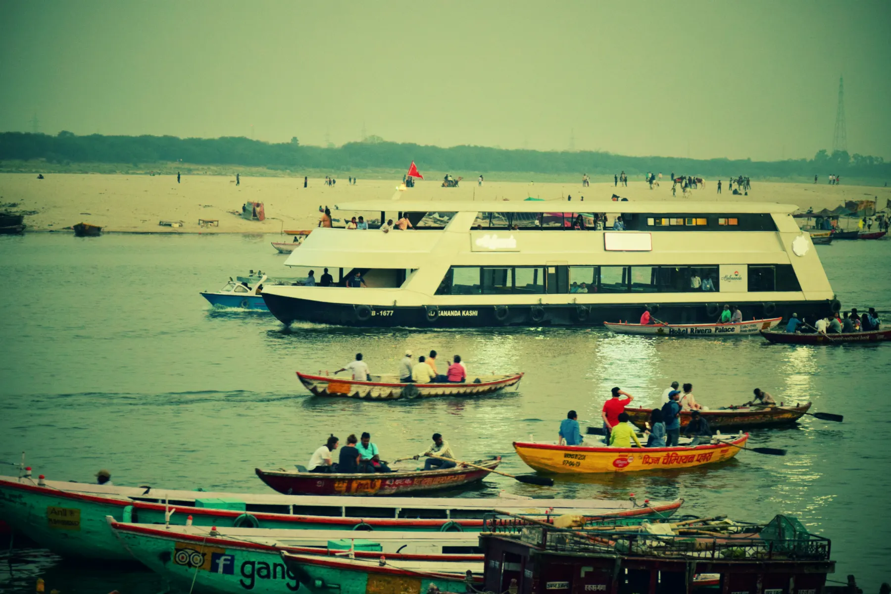 A cruise boat and rowing boats on the Ganga
