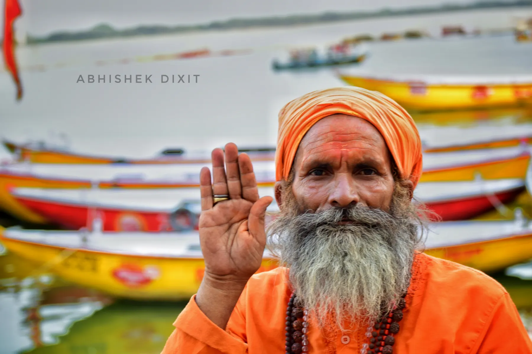 A sadhu in saffron raising his hand in blessing