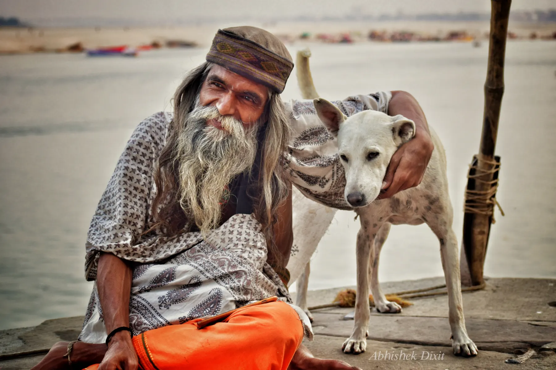 An elderly sadhu with his dog on the ghats